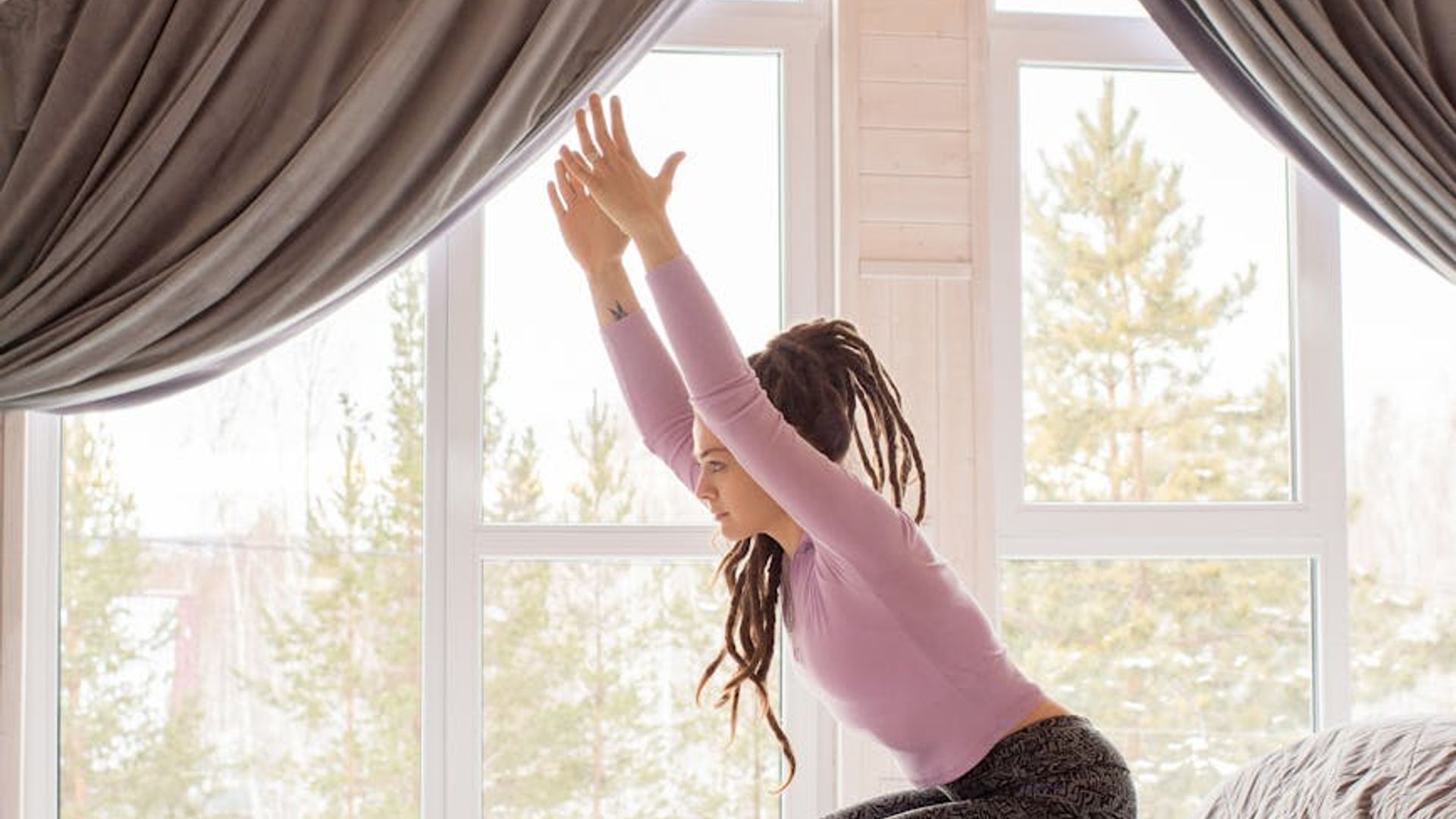 Minimalist yoga studio with soft morning sunlight entering through large windows.